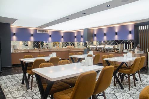 un ristorante con tavoli, sedie e un bancone di SWEET HOME SUiTE HOTEL a Trabzon
