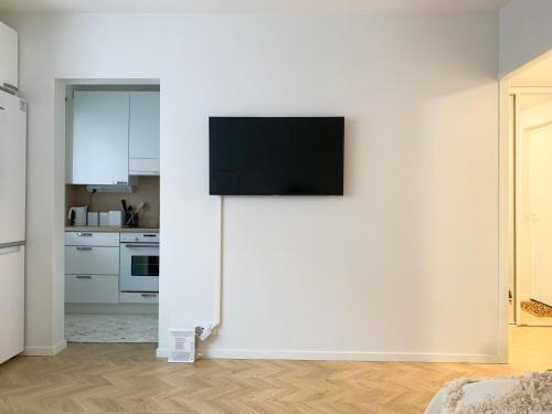 a living room with a tv on a white wall at Cityview Design Apartment Amber in Lahti