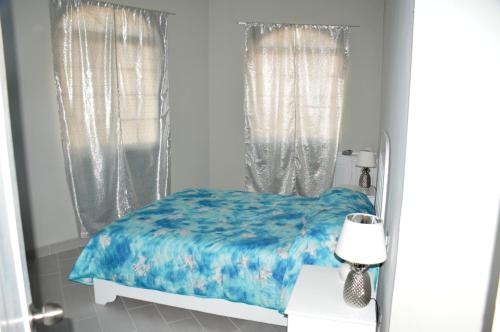 une chambre avec un lit recouvert d'une couette bleue dans l'établissement Caribe Apartament S&D el castillo dominicus Apartamento #9, à Bayahibe