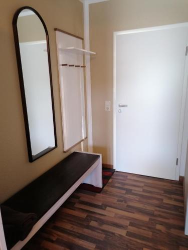 a room with a mirror and a bench and a door at Pension Mien Fründt in Baabe