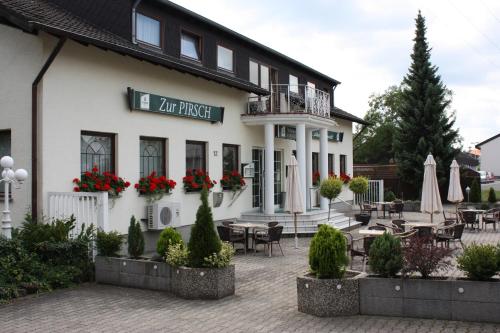 ein Hotel mit Tischen und Stühlen im Innenhof in der Unterkunft Hotel Pirsch in Ramstein-Miesenbach