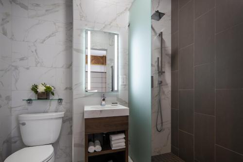 a bathroom with a toilet and a sink and a mirror at Hotel 32One in San Francisco