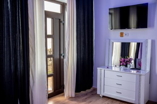 a room with a dresser with a mirror and a window at Casa Robi in Peştişani