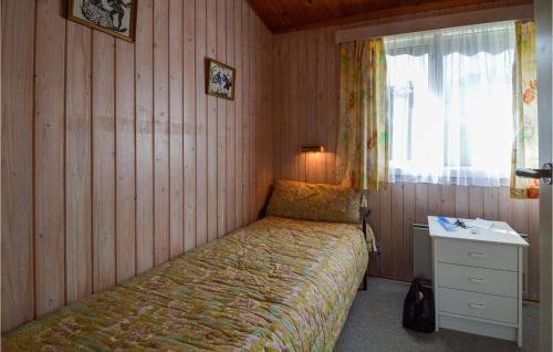 a bedroom with a bed and a desk and a window at Beach Front Home In Stubbekøbing in Stubbekøbing