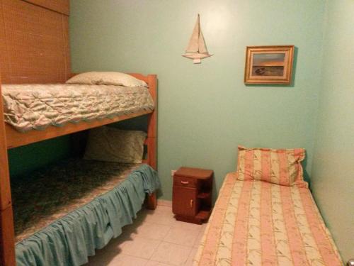 Tucacas的住宿－Costa Grande Tucacas Morrocoy，一间卧室配有两张双层床和一张小床。