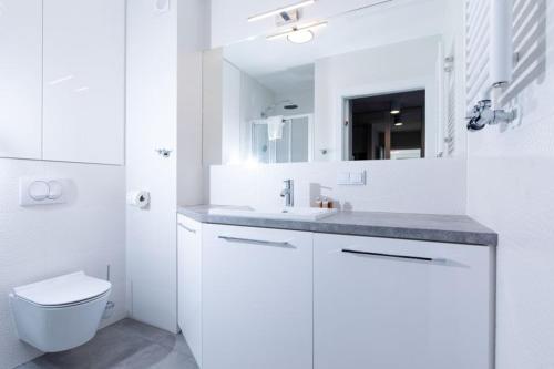 Baño blanco con aseo y lavamanos en Resort Apartamenty Klifowa Rewal 30 en Rewal