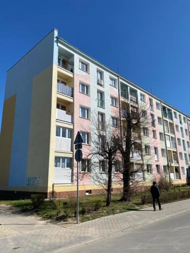a man standing in front of a large building at APARTAMENT OŚ. BŁĘKITNE 10H in Dzierżoniów