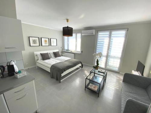 a bedroom with a bed and a living room at APARTAMENT OŚ. BŁĘKITNE 10H in Dzierżoniów