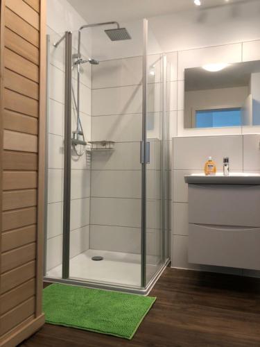 a shower with a glass door in a bathroom at FeWo am Meer Schillig-Nordsee 47.4.M in Wangerland