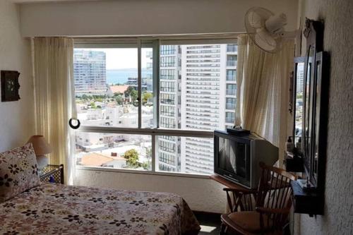 Habitación de hotel con cama y ventana grande en Torres del Plata II, Frente a la Playa!, en Punta del Este