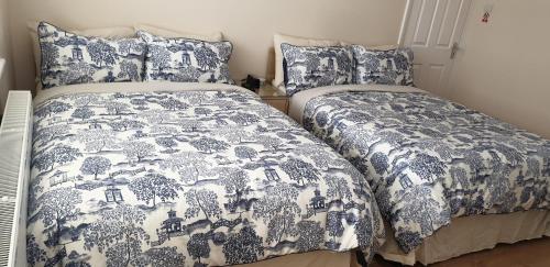 Duas camas num quarto com roupa de cama azul e branca em London Luxury 3 Bedroom Flat 1min walk from Underground, with FREE PARKING Sleeps x10 em Londres