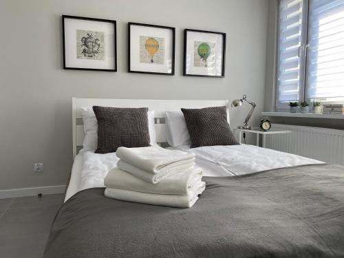 a bedroom with a bed with white towels on it at APARTAMENT OŚ. BŁĘKITNE 10H in Dzierżoniów