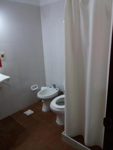 a white bathroom with a toilet and a sink at Estancia Renacimiento in Atlántida