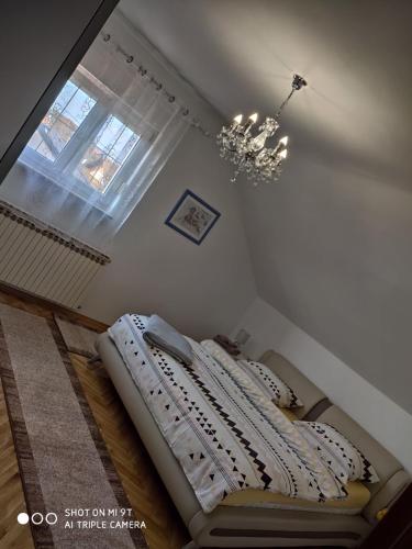 a bedroom with two beds and a chandelier at Kaya 2 in Đakovo