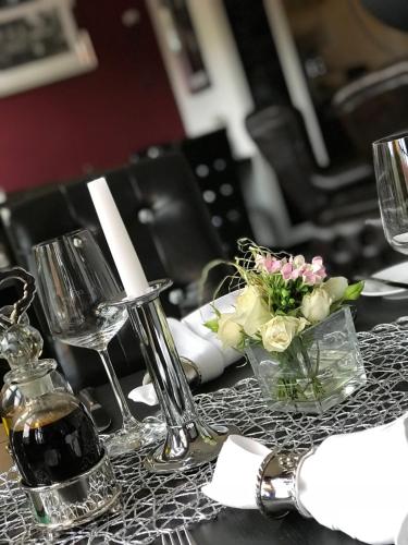 a table with a centerpiece of flowers and wine glasses at Boutique Hotel Schulz Classic in Neustadt am Rübenberge