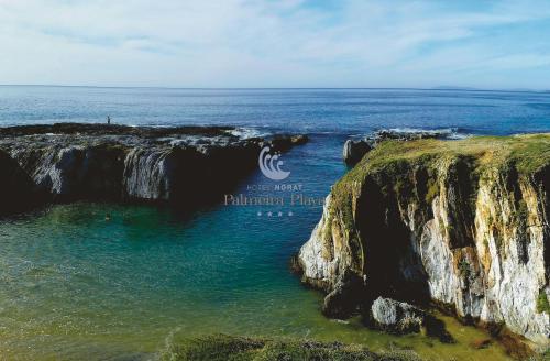 a view of the ocean from a cliff at Hotel Norat Palmeira Playa in Ribeira