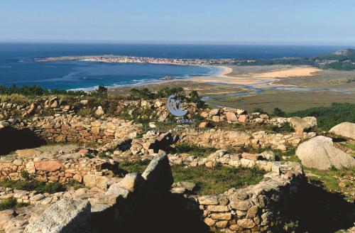 an aerial view of a rocky shoreline with the ocean at Hotel Norat Palmeira Playa in Ribeira