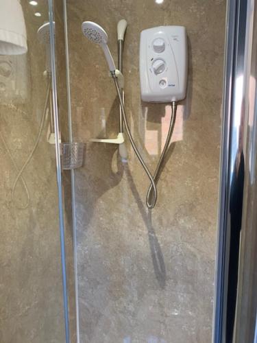 a shower with a blow dryer in a bathroom at The Firs at Hay-on-Wye B&B in Hay-on-Wye