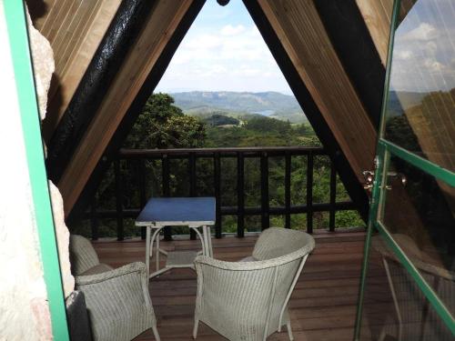 a room with a balcony with chairs and a table at Madrugada in Umtali