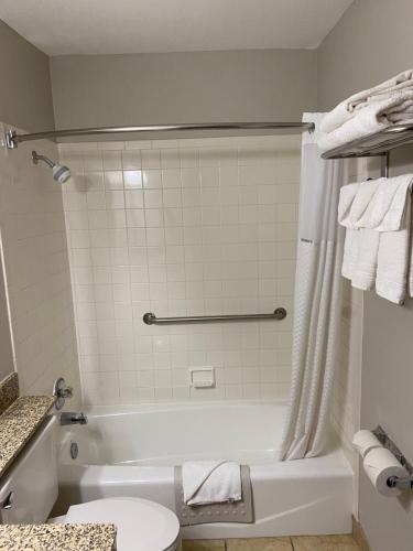 a bathroom with a white tub and a toilet at Days Inn & Suites by Wyndham Des Moines Airport in Des Moines