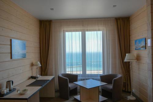a room with a desk and chairs and a large window at Chayka Resort in Odesa