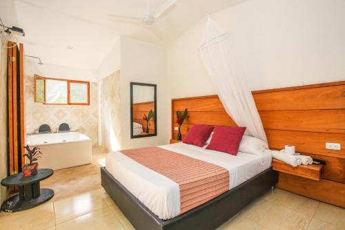 
a bedroom with a bed and a dresser at Manigua Tayrona Hotel in El Zaino
