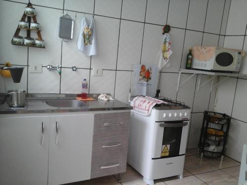 a small kitchen with a stove and a sink at Villa Maria DA Luz ROCHA Olimpia in Olímpia
