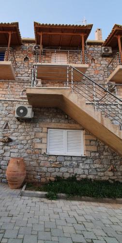 a stone building with stairs on the side of it at Stoupa Lefktro 3 in Stoupa