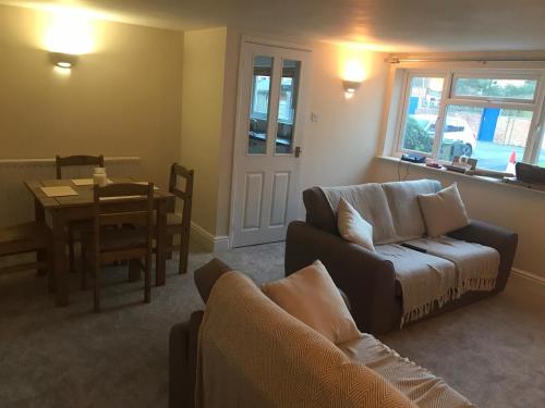 a living room with a couch and a table at 9 Bromleys Court in Church Stretton