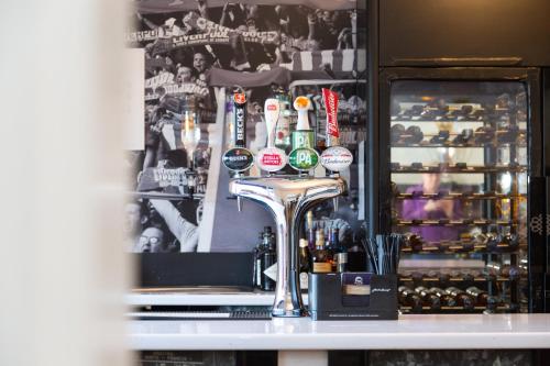 a bar with bottles of alcohol on a counter at Hotel Anfield in Liverpool
