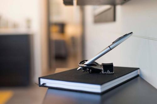 a pen sitting on top of a book on a table at The Zephyr Modern Luxe Container Home in Bellmead