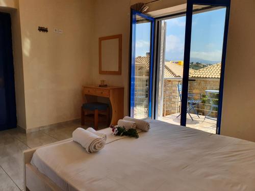 a bedroom with a bed with a desk and a window at Stoupa Lefktro 4 in Stoupa