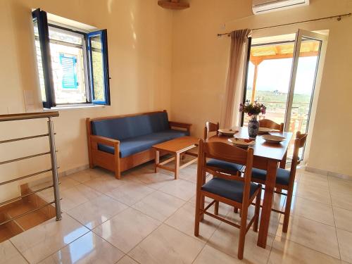 Una sala de estar con una mesa y un sofá azul. en Stoupa Lefktro 4, en Stoupa
