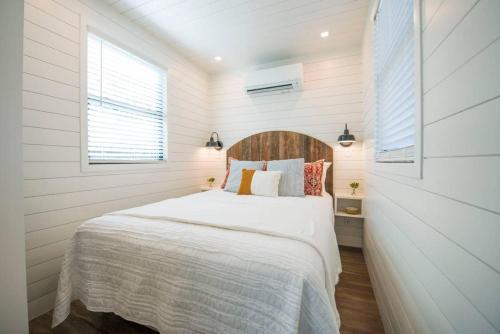 Cool River "Helm" Container Home في Bellmead: غرفة نوم بسرير في غرفة بيضاء