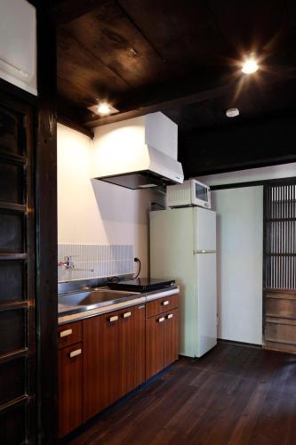 a kitchen with wooden cabinets and a white refrigerator at Mihokan in Mihonosekichō