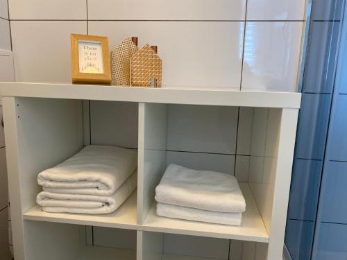 biała półka z ręcznikami w łazience w obiekcie APARTAMENT OŚ. BŁĘKITNE 10H w mieście Dzierżoniów