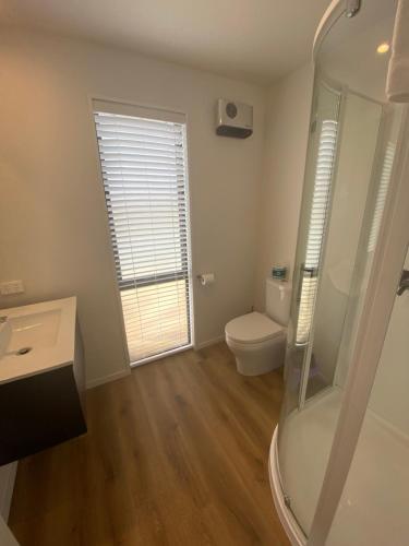 a bathroom with a toilet and a glass shower at Starview 88 Apartment in Lake Tekapo