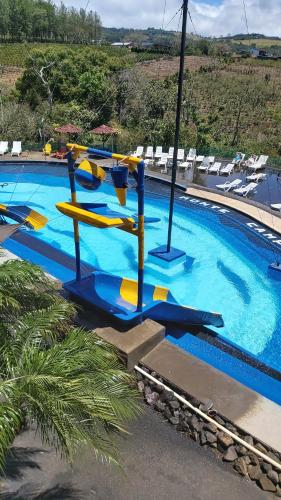 a large swimming pool with a water slide at Hotel Monte Campana Heredia in Birrí