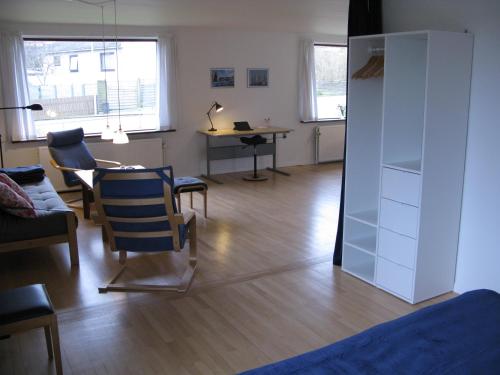a living room with a table and chairs and a desk at Fuglevænget in Hundested