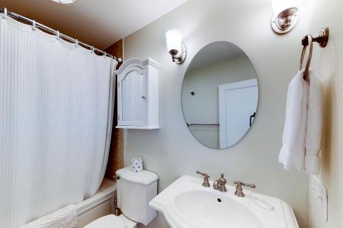 W łazience znajduje się umywalka, toaleta i lustro. w obiekcie Library House w mieście Durango