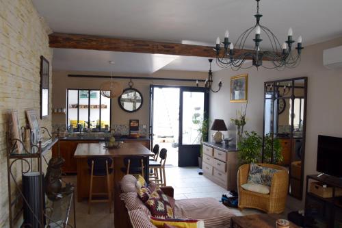 a kitchen and living room with a table and chairs at Le Petit Patio in Aigues-Mortes
