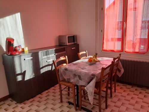 une cuisine avec une table et des chaises et un micro-ondes dans l'établissement La petite escale, à Vierzon