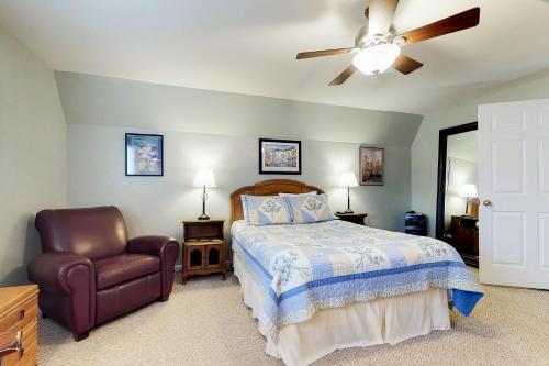 a bedroom with a bed and a chair and a ceiling fan at Gunni Getaway in Gunnison