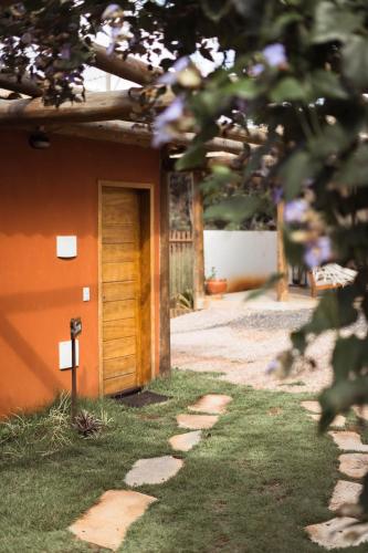 a door to a house with a grass yard at Vila Gaia Guest House in Alto Paraíso de Goiás