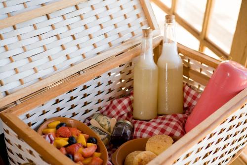 a basket with two bottles of milk and a bowl of fruit at Vila Gaia Guest House in Alto Paraíso de Goiás