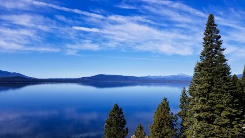 a view of a lake with trees in the foreground at Cedar Ridge Retreat Lake Almanor in Lake Almanor