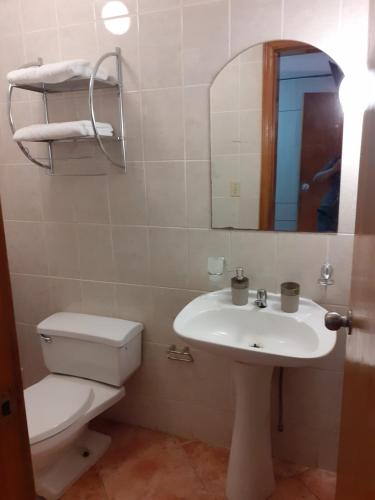 a bathroom with a toilet and a sink and a mirror at Inka Ayllu Hospedaje in Lima