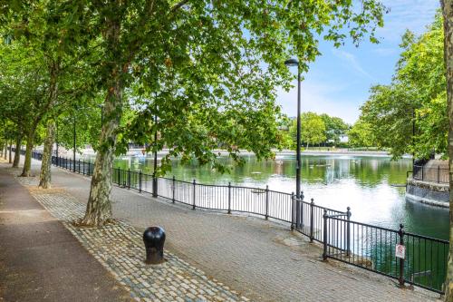 a sidewalk next to a river with a fence at One Bedroom Modern Apartment Next to Wembley Stadium! in London