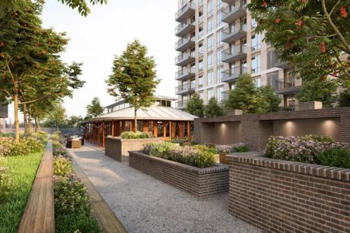 a courtyard with a building and a building with plants at One Bedroom Modern Apartment Next to Wembley Stadium! in London
