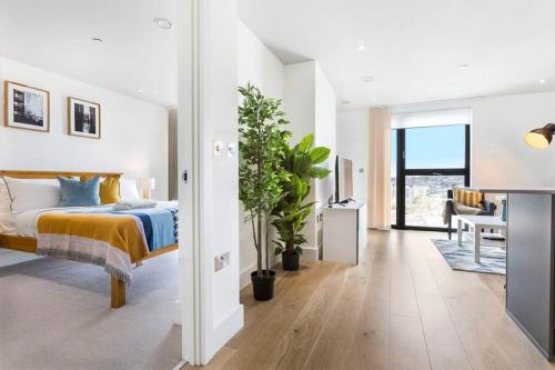 One Bedroom Modern Apartment Next to Wembley Stadium! في لندن: غرفة نوم مع سرير وغرفة معيشة